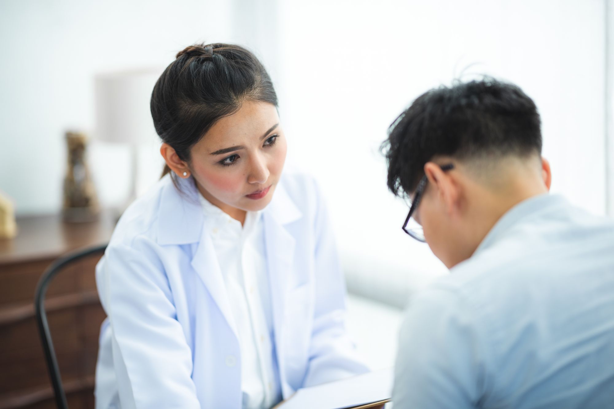 A clinician calmly listening to an upset patient