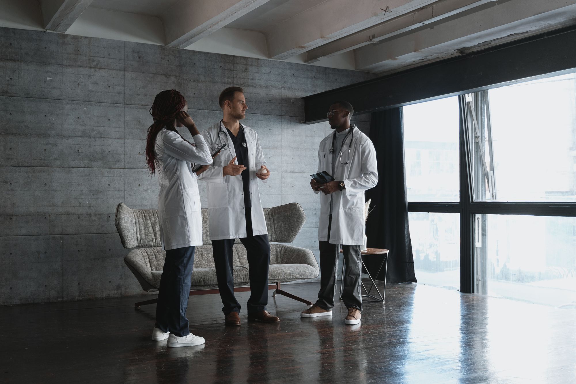 Three clinicians talking together in a modern practice space