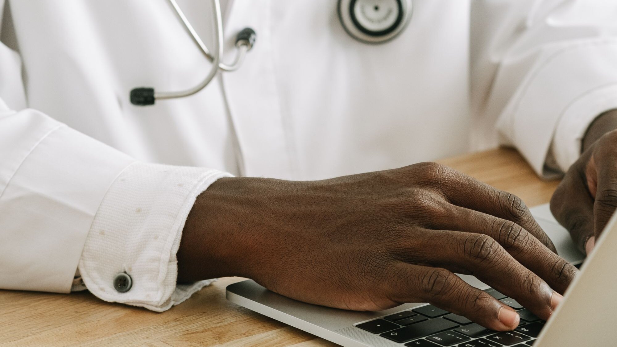 Clinician reviewing and approving an AI-generated clinical note on a laptop