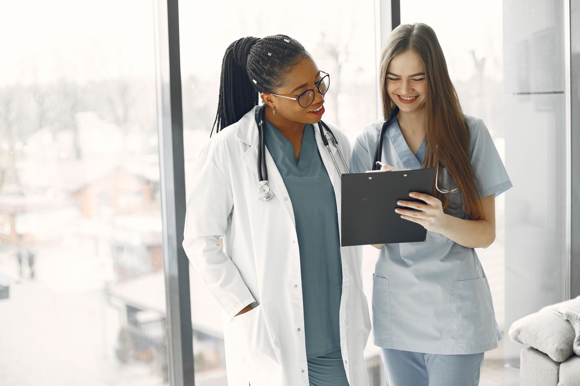 Two clinicians reviewing a patient chart together on a clipboard