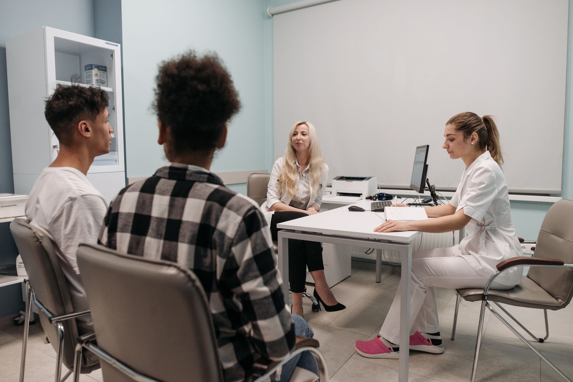 A clinician talking with patients during an appointment in a clinic