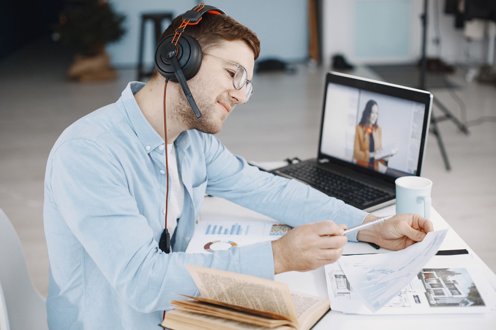 A person wearing a headset reviewing documents during a call