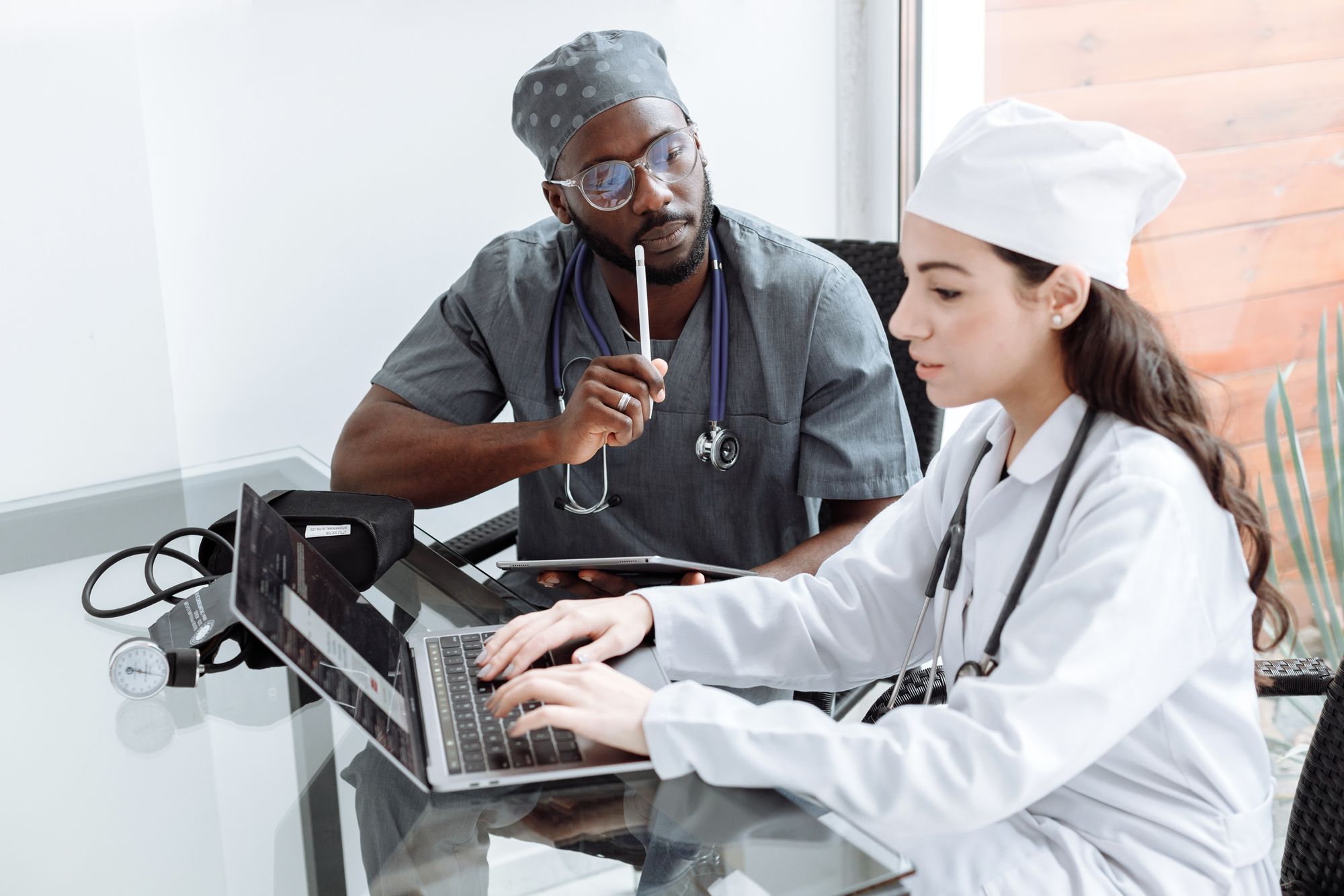 Two physicians discussing a case over a laptop