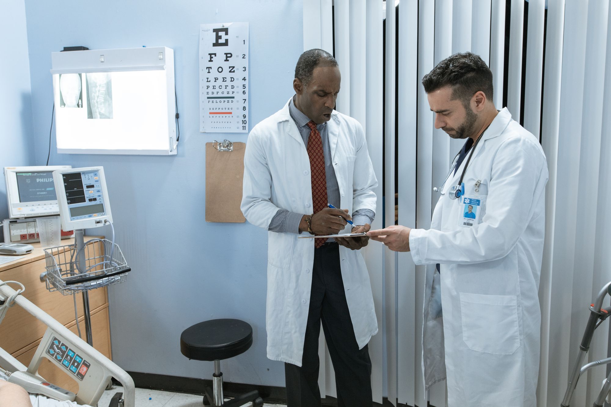 Two clinicians in white coats discussing a patient chart