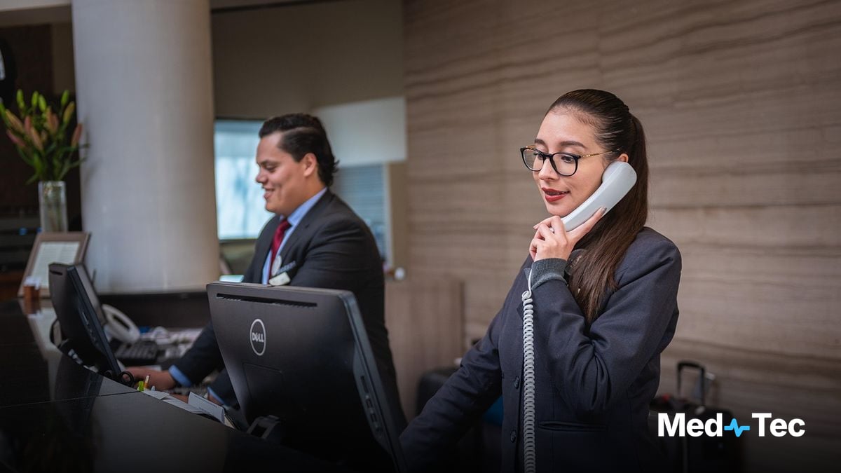 A front desk team member greeting a patient in a small clinic