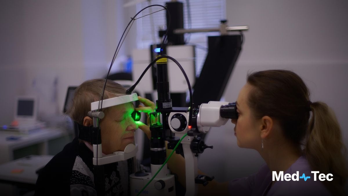 A clinician chatting with a patient in a bright exam room, tablet nearby