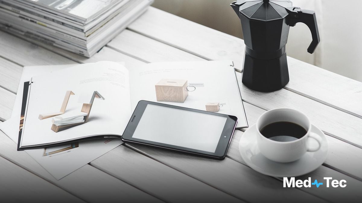 A nurse practitioner reviewing a visit note on a tablet